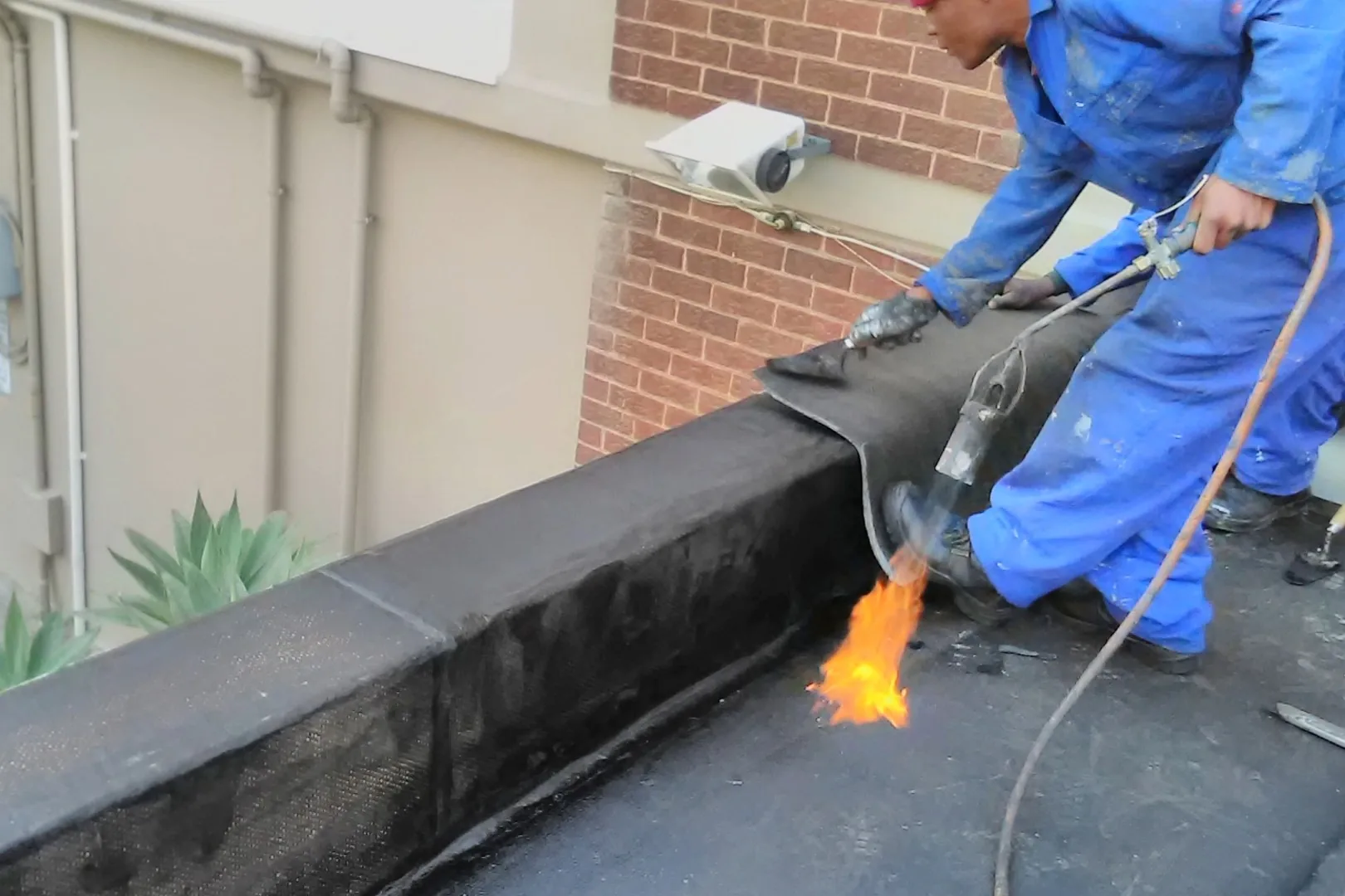 Drytek installing torch-on waterproofing membrane on a flat roof in Bedfordview